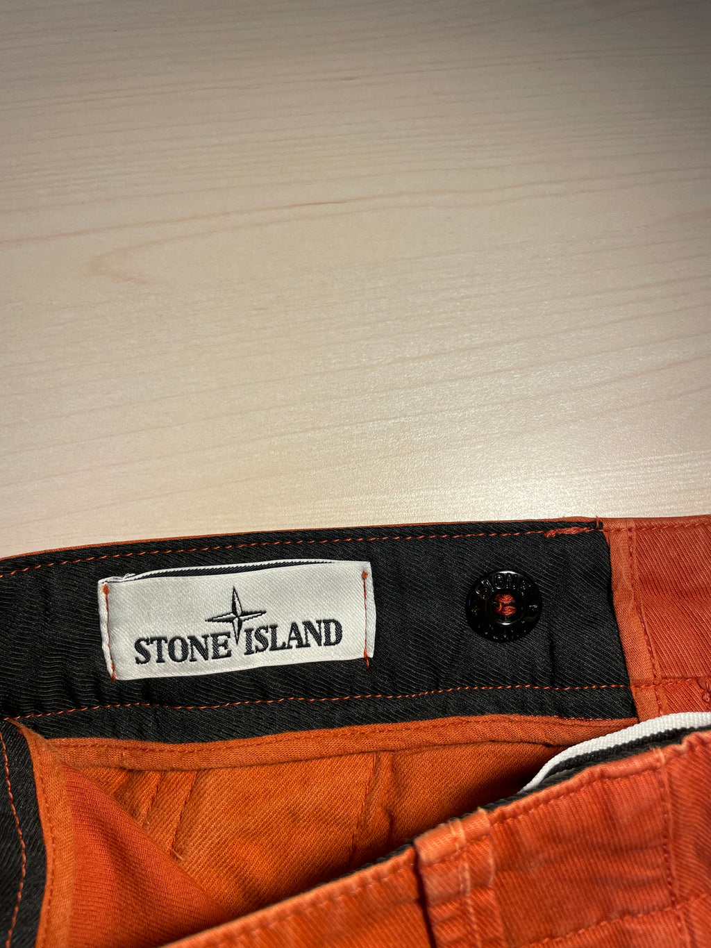 Pantaloni Stone Island arancioni logo retro